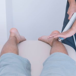 The physiotherapist treating a man using equipment for radio therapy