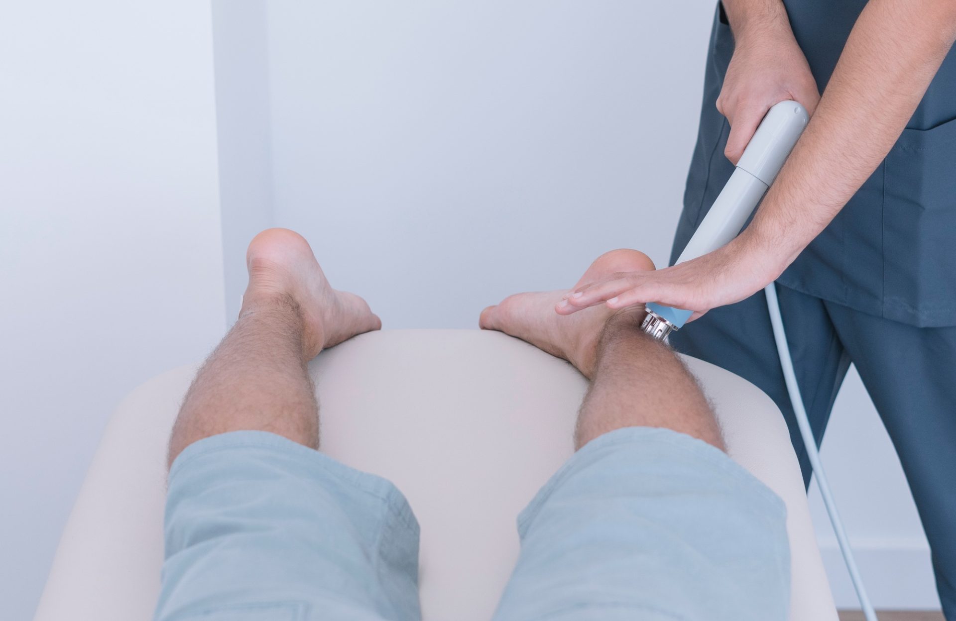 The physiotherapist treating a man using equipment for radio therapy